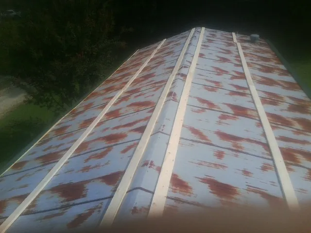 Rusted metal roof panels with new wood purlins before replacement — Storm Damage Roof Repair in New Smyrna Beach by Roofing Brothers