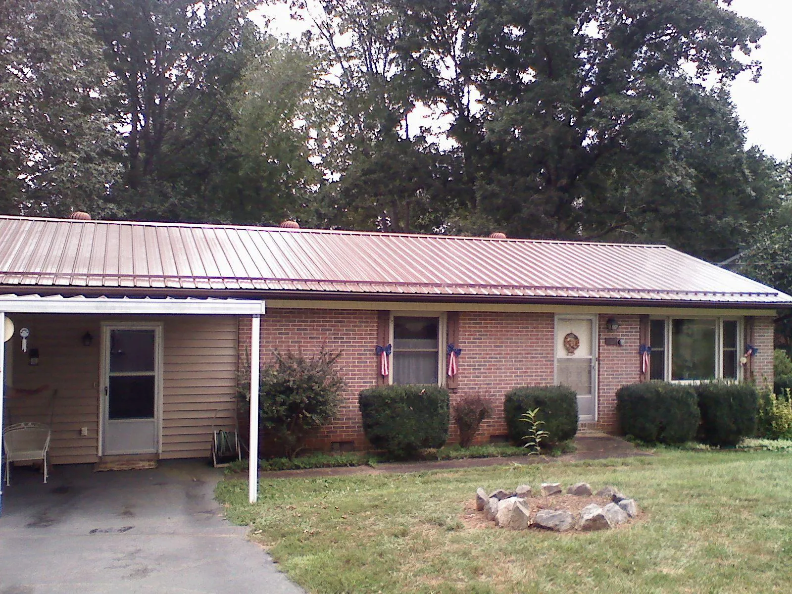 Bronze metal roof and carport on a brick ranch home — Roof Repair work by our crew in New Smyrna Beach